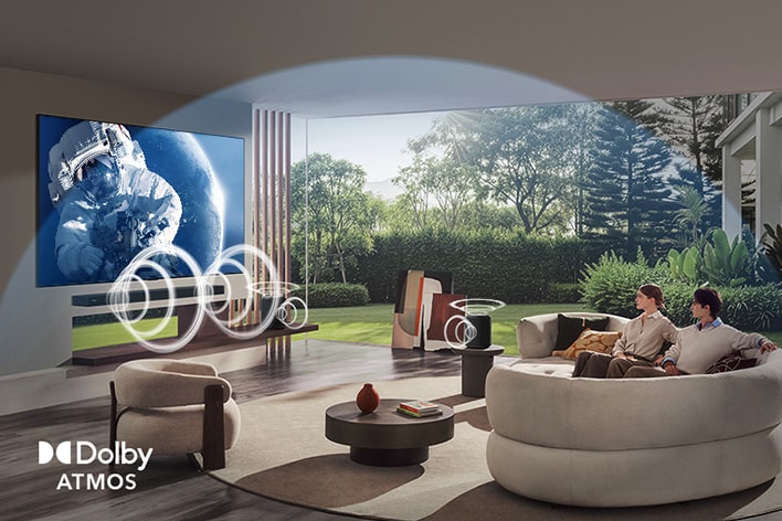 LG OLED evo AI B6 con Dolby Atmos muestra una escena espacial amplia en una sala de estar, con ondas de sonido gráficas que rodean a los espectadores y a los parlantes para indicar un audio envolvente, multidireccional y basado en objetos.