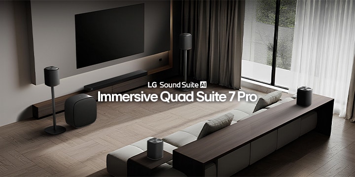 Een woonkamer met een tv en een Sound Suite-set, met een soundbar aan de muur, een woofer aan de voorkant, een paar luidsprekers op zijstandaards en nog een ander paar achter de bank.