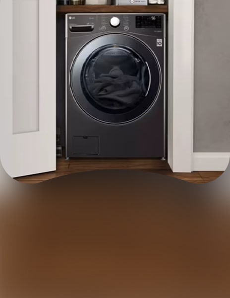 LG washing machine in a compact closet with neatly organised shelves holding towels and laundry supplies, highlighting an efficient use of space.