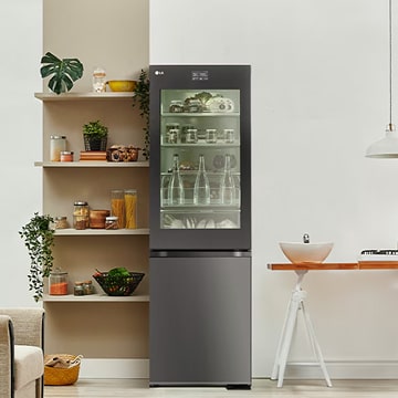 Refrigerador LG con congelador inferior en una cocina moderna con panel de vidrio InstaView, que ofrece fácil acceso a los alimentos frescos y un diseño elegante y compacto.