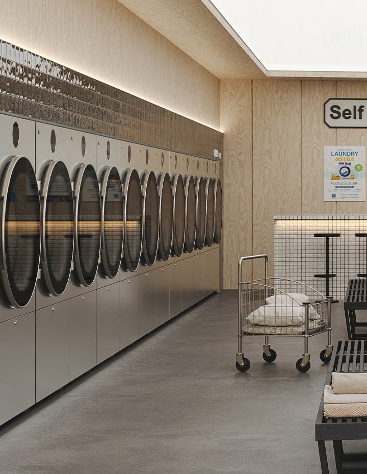 Premium self service laundry space with warm lighting, modern machines, and central folding area