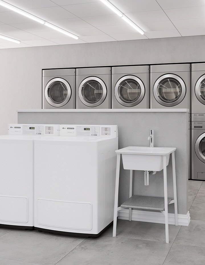 Shared laundry room with multiple commercial washers and dryers arranged in a residential building	
