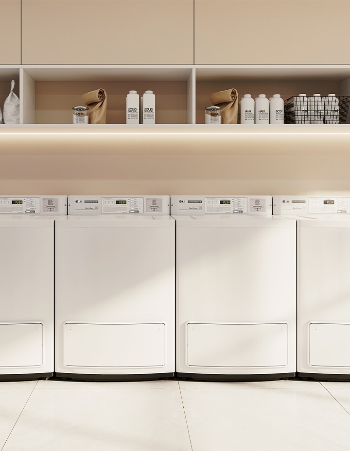 Row of commercial top-load washers installed in a modern shared laundry room with clean, minimalist interior design