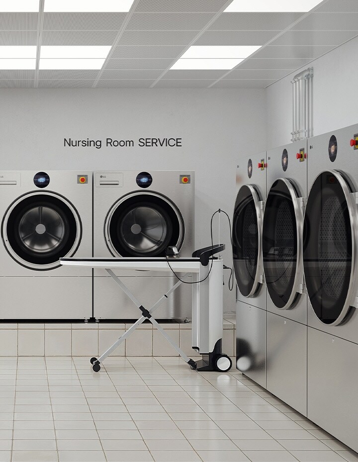 Hospital nursing room laundry facility with commercial washers, dryers, worktables, and folded linens	