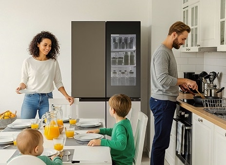 LG InstaView fridge freezer in a bright kitchen. The door shows orange juice inside. A man cooks while two children in green shirts look at their mother.