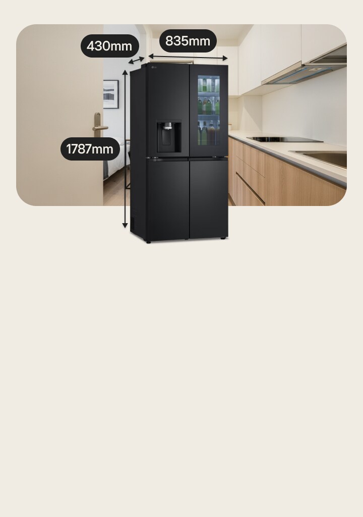 Black LG medium-sized fridge freezer with InstaView door and water dispenser. Behind it, a bed is on the left and a kitchen with induction hob on the right.