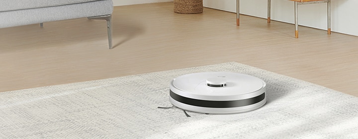 LG robot vacuum cleaner operating on a floor surface in a modern home interior.
