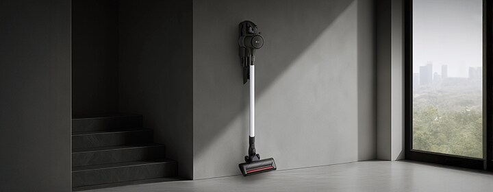 LG handstick vacuum mounted on a wall in a modern interior with clean minimalist design.