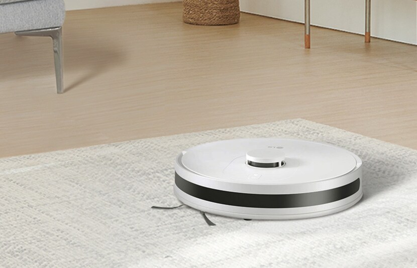 LG robot vacuum cleaner operating on a floor surface in a modern home interior.
