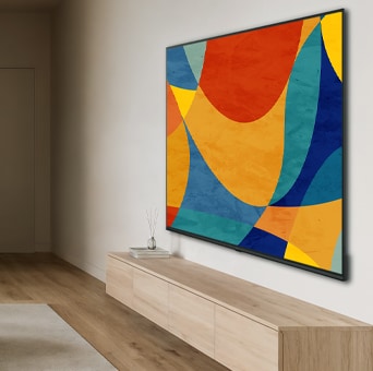 LG NANO 4K UHD AI NU80 with a Slim Design is wall-mounted in a bright, open living space, featuring a sleek profile that blends seamlessly into the interior while displaying vibrant, multicolored abstract shapes across the screen.