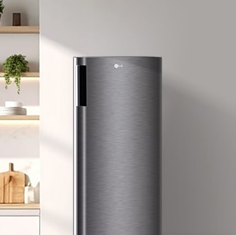 توجد ثلاجة طويلة ذات باب واحد من LG على جانب جدار بسيط.