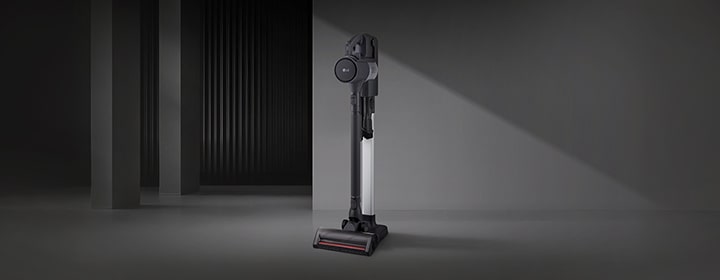 LG handstick vacuum in a floor-standing setup displayed in a modern interior space.