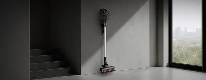 LG handstick vacuum mounted on a wall in a modern interior with clean minimalist design.