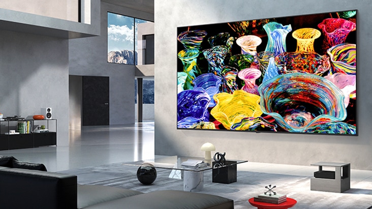 LG Mini RGB evo AI MRGB9M True Wireless TV with Zero Connect Box is wall-mounted in a spacious modern living room, displaying vibrant abstract artwork with a cable-free setup that keeps the space clean and uncluttered.