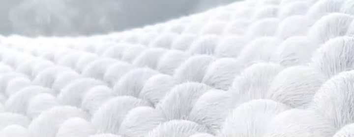 Närbild på LG-tvättmaskin med ångfunktion med visualisering av ånga som försiktigt penetrerar och mjukgör tygfibrer