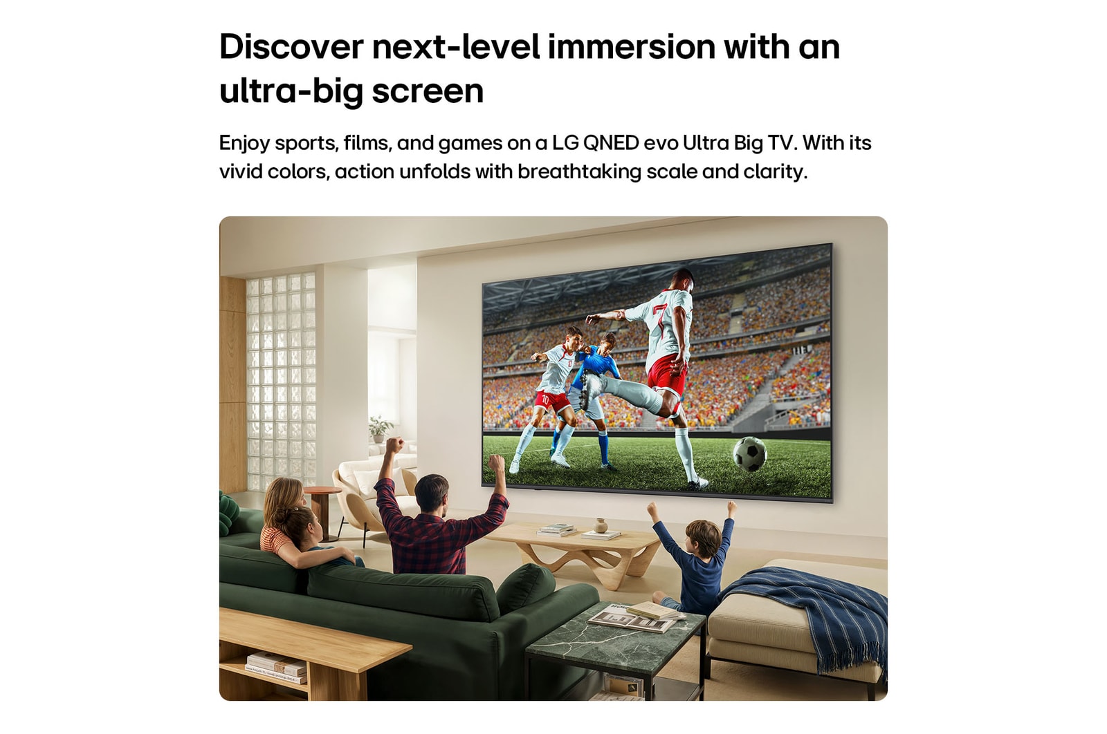 LG QNED evo AI QNED82 Mini LED ultrastor TV visar en intensiv fotbollssituation i stor skala med förfinad bildkvalitet och intensiva färger, medan en familj hejar på tillsammans från soffor i ett vardagsrum.