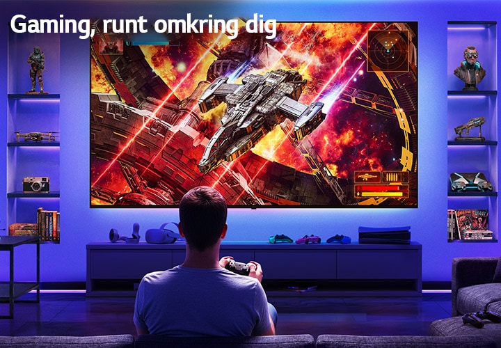 En LG Ultra Big TV är väggmonterad i ett neonbelyst spelrum, där en stor skärm visar en levande rymdstridsscen medan en spelare sitter vänd mot skärmen, vilket illustrerar en uppslukande och engagerande spelupplevelse.