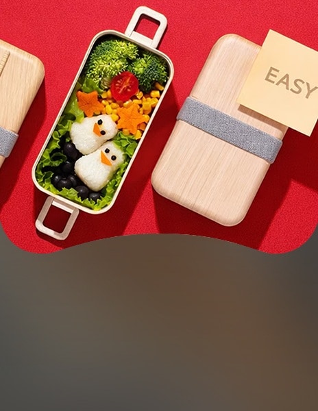 An image showing an easy bento box meal with penguin-shaped rice balls and colorful vegetables on a red background, illustrating a simple meal-prep concept.