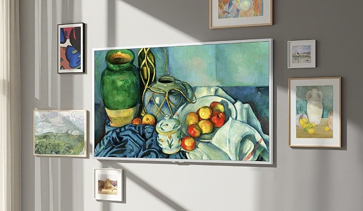 De LG Gallery TV AI met frame LX7 ART TV met Gallery-like Screen hangt aan de muur met een stilleven op het scherm. De TV hangt naast een raam met andere ingelijste kunstwerken en ondanks het zonlicht zijn er geen zichtbare reflecties op het scherm, waardoor het eruitziet als echte kunst.