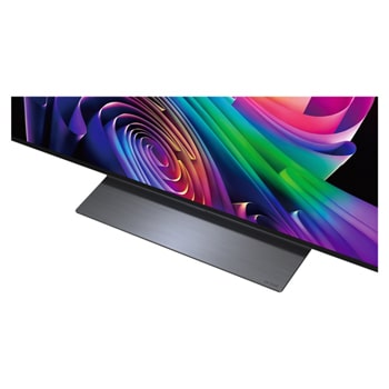 LG OLED evo AI C6 is wall-mounted in a styled living space, featuring an ultra-slim design with narrow bezels, and it displays a riverside cityscape at sunset on screen.