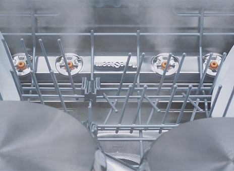 Dishwasher interior with TrueSteam removing spots and cleaning dishes.