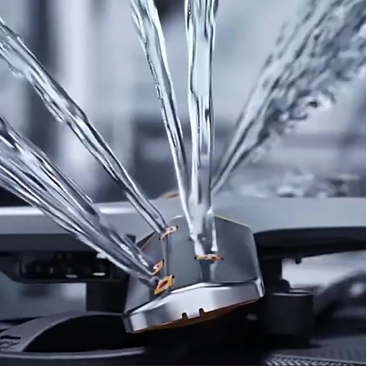 Footage of intense water streams from rotating dishwasher blades in close-up.