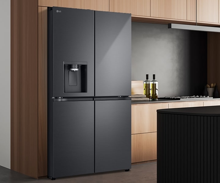 LG smart refrigerator with matte black finish installed in a modern kitchen featuring an island counter and bar stools