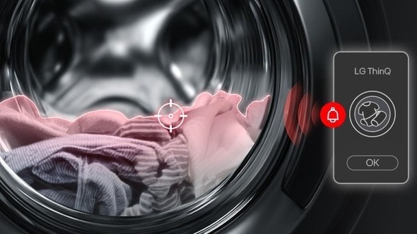 LG front load washing machine with LG ThinQ alert showing laundry inside drum and notification for smart care
