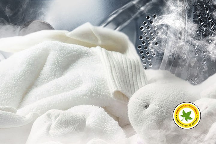 lg washing machine with white laundry and a stuffed toy being washed with steam