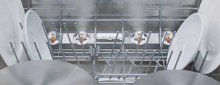 LG dishwasher interior with steam cleaning removing residue from dishes and cookware.