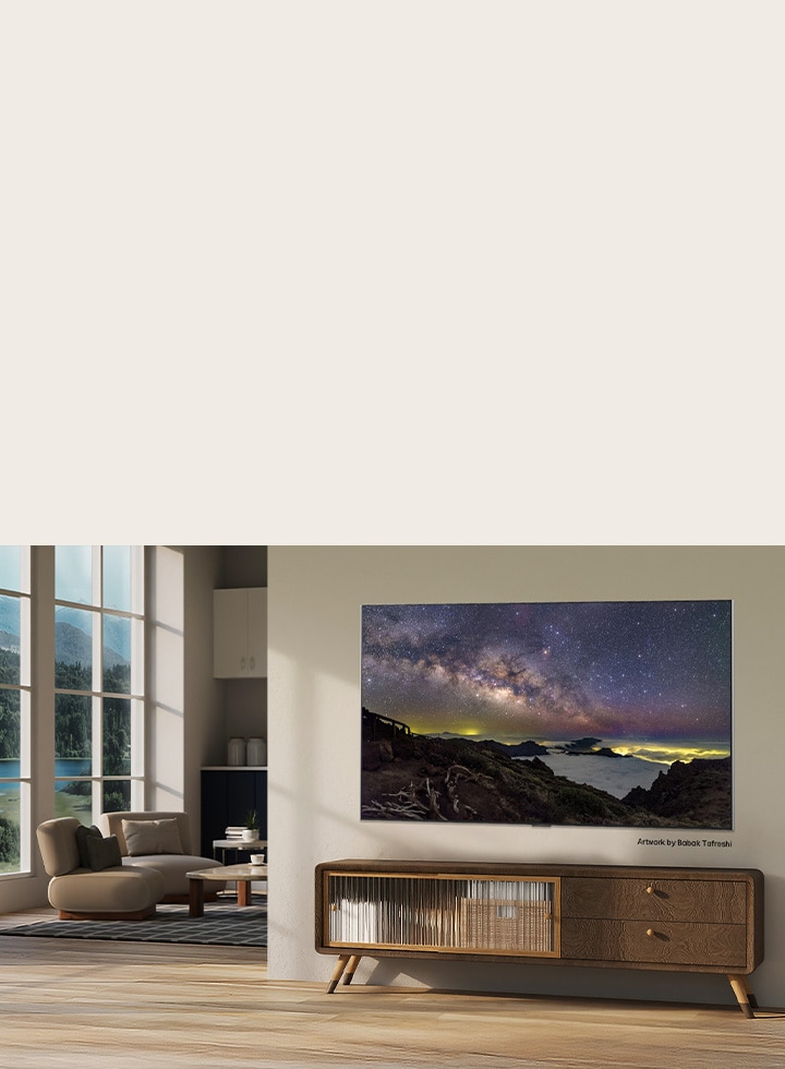 LG Micro RGB evo AI MRGB95 with LG Gallery+, offering diverse art content, displays a night-sky landscape artwork by Babak Tafreshi in a modern living space as part of a curated art experience within the TV interface.	