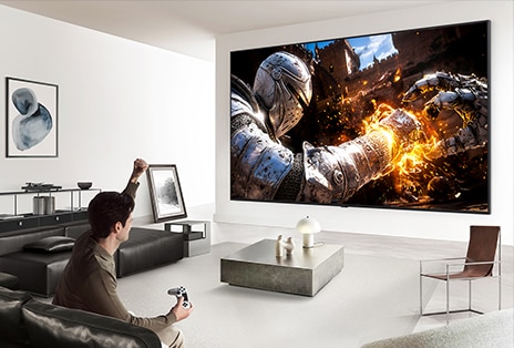 LG Mini RGB evo AI MRGB9M with a hassle-free approach displays an action game scene, with device connections managed wirelessly through the Zero Connect Box to reduce setup complexity around the TV.