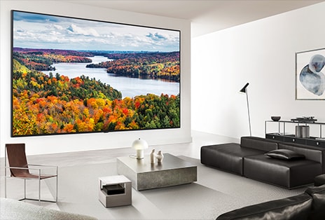 LG Mini RGB evo AI MRGB9M highlights Location-Free flexibility. It is shown cleanly wall-mounted in a room with a vivid landscape on screen, enabling wireless installation tailored to personal style and space.