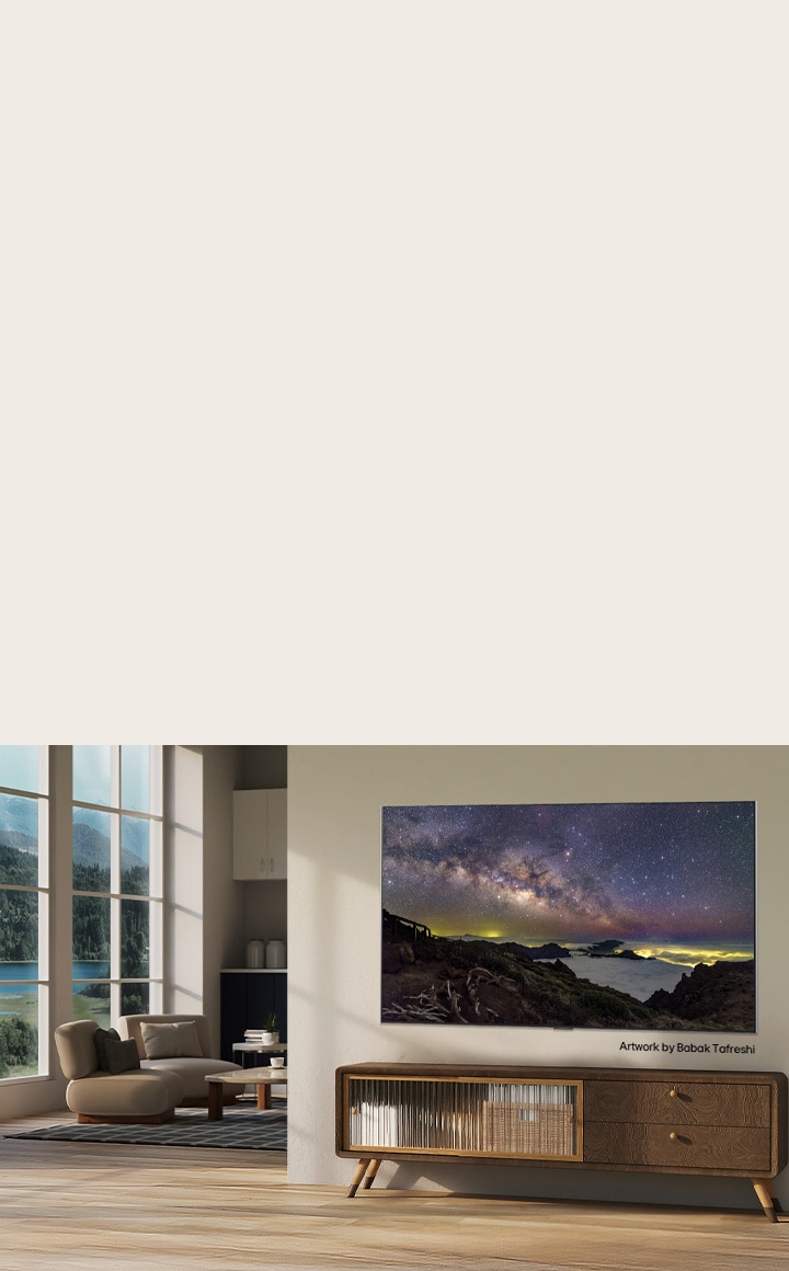 Interior of a countryside home. A huge wall-mounted LG TV is displaying a beautiful natural landscape artwork on its screen. The TV looks like a photograph hung on the wall.