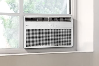 Một chiếc máy điều hòa cửa sổ màu trắng được lắp đặt trong khung cửa sổ, để lộ màn hình hiển thị kỹ thuật số và các khe thông gió.