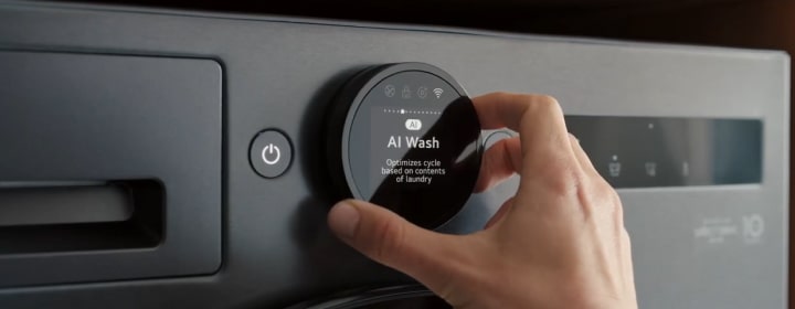 Nút xoay điều khiển của máy giặt tự động LG đang được vặn bằng tay trên bảng điều khiển máy giặt cửa trước