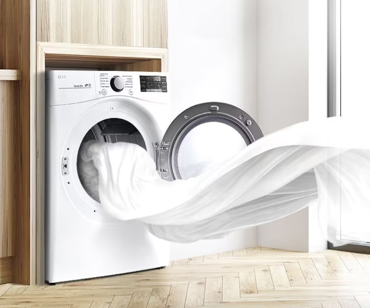Máy sấy LG phả ra luồng khí ấm khi lấy quần áo sạch ra khỏi lồng giặt trong phòng giặt sáng sủa