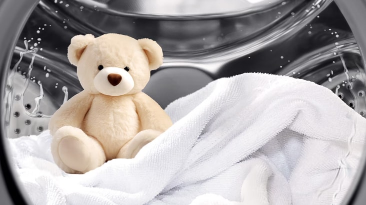 Hình ảnh tính năng Steam của LG thể hiện gấu bông và vải trắng bên trong lồng máy giặt