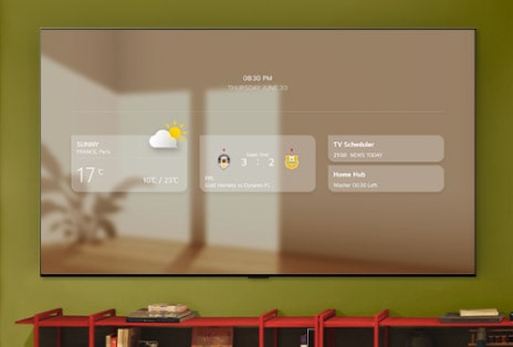 LG ART TV treo ở bức tường xanh lá, phía trên kệ tủ đỏ hiển thị bảng thông tin bao gồm thời tiết, tỉ số thể thao, Trình lên lịch xem TV và Home Hub.