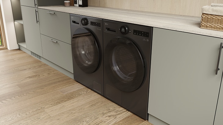 LG black washer and dryer set, built under a light countertop within neutral cabinetry on wood flooring with a clean layout.	
