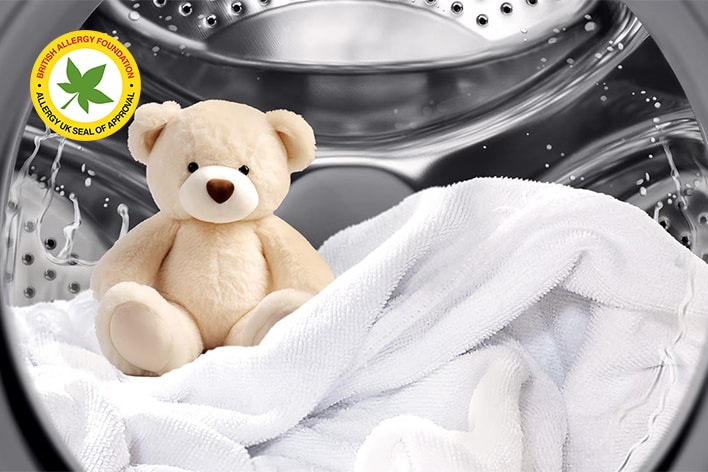 LG dryer with teddy bear and white towels in the drum, approved by British Allergy Foundation for allergy-friendly care	