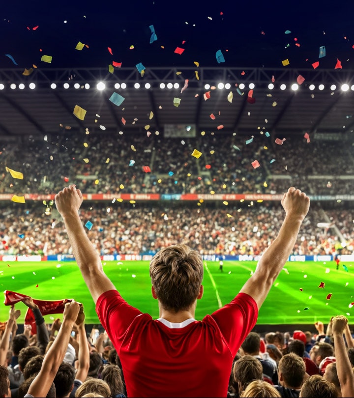 LG QNED evo AI Mini LED with Dynamic Color on an Ultra Big screen centers on a fan in a red shirt celebrating, as the packed stadium scene is revealed on a massive TV in a living room, highlighting lifelike scale and vivid color at home.