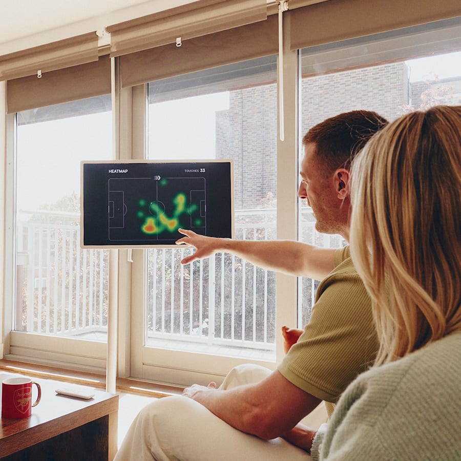 Ein Mann, der auf einen StanbyME 2 Smart Screen zeigt und die Heatmap eines Fußballspielers erklärt.