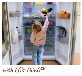 Ein Kleinkind greift in einen offenen, beleuchteten Kühlschrank. [mit LG ThinQ™]