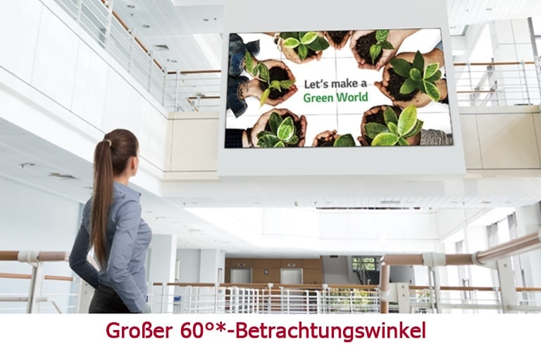 Eine Frau blickt auf ein im Obergeschoss angebrachtes Display.