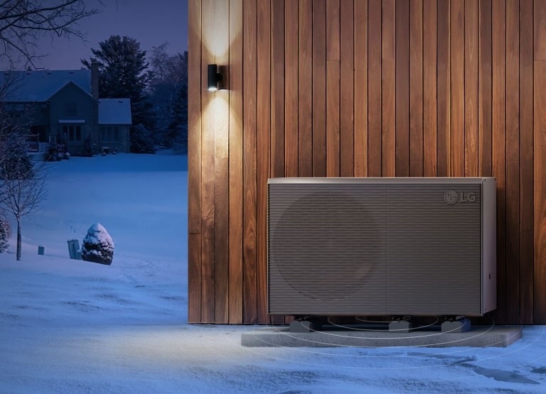 Mit QUIET MARK werden LG THERMA V Produkte vor der Außenwand eines Holzhauses vor der Kulisse der verschneiten Dörfer platziert.