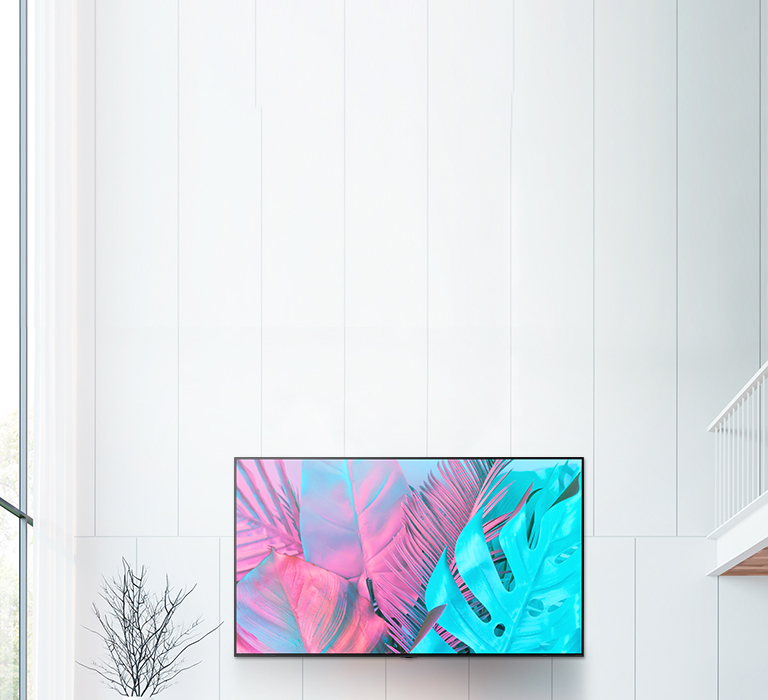 Ein großer Flachbildfernseher ist an einer weißen Wand montiert. Der Bildschirm zeigt große Blätter in leuchtenden Farben.