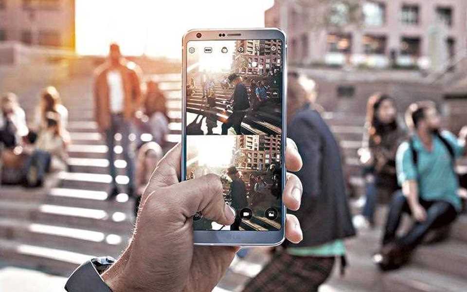 An image of person holding lg g6 to take photography with new square mode feature