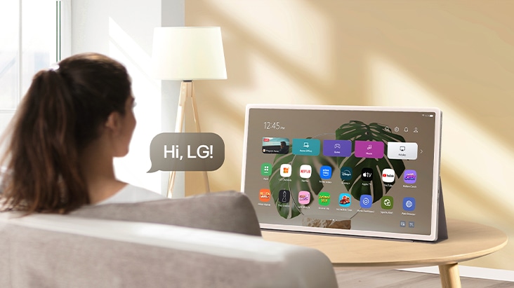 A person using voice recognition on StanbyME 2, and a speech bubble with text that reads Hi, LG!