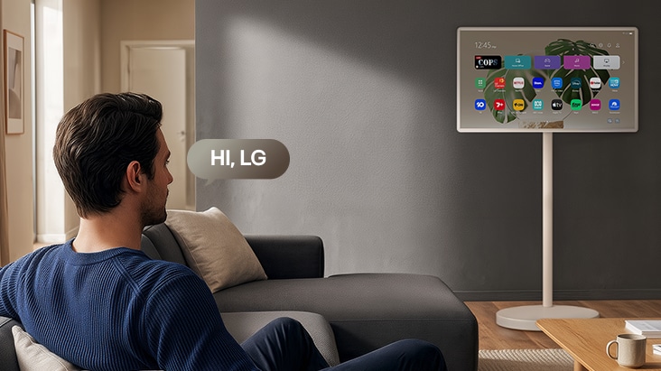 LG StanbyME 2 Max LX6 Movable Screen with Far Field Voice Recognition is activated by a voice command as a person seated in a room says “Hi, LG” toward the screen, indicating hands-free voice interaction within the TV interface.